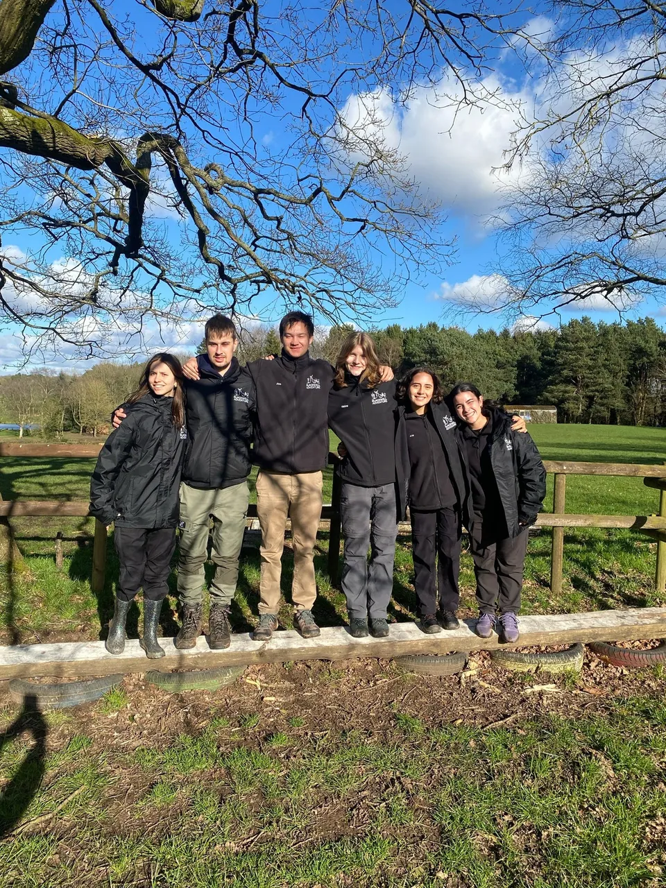Grupo de participantes con ropa de abrigo en un prado de Blackwell Adventure