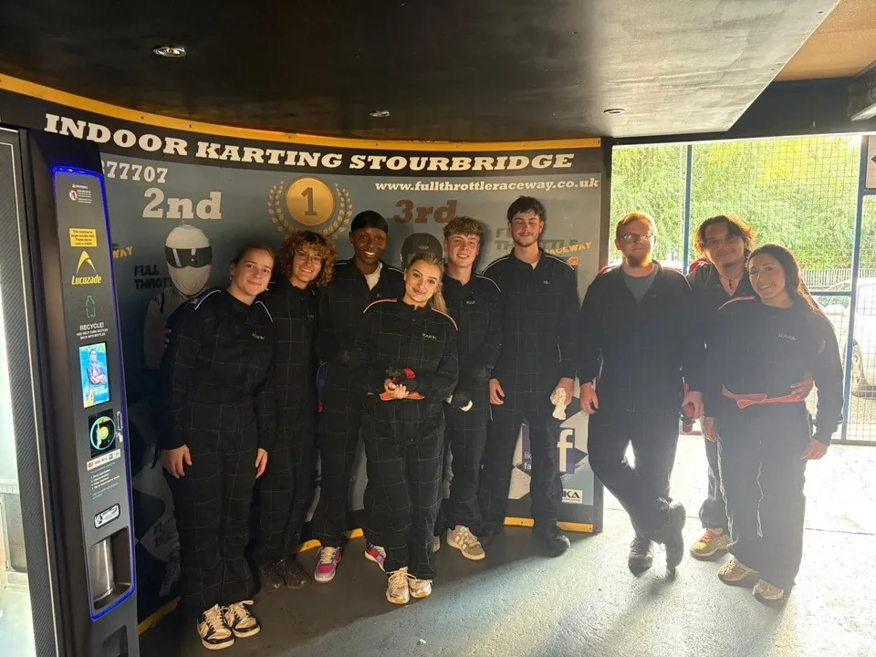 Grupo de participantes de Blackwell en una pista de karting bajo techo